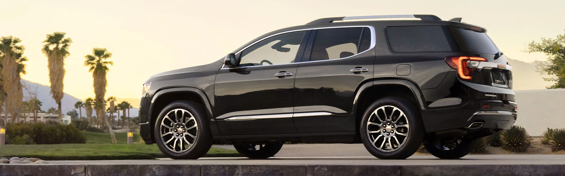 Black GMC Acadia loking over a city